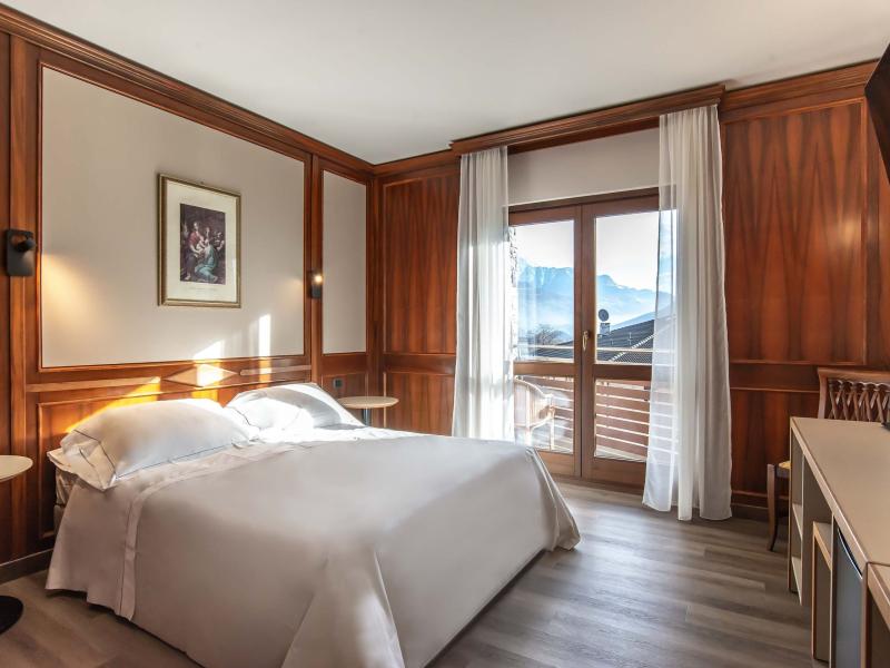 Chambre élégante avec vue sur la montagne, mobilier en bois et lit double.